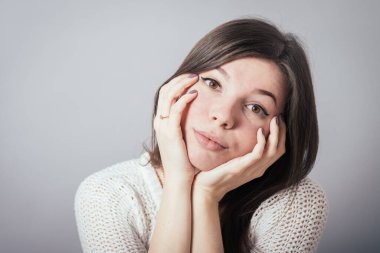 Kız, başını ellerinin üzerine koydu.