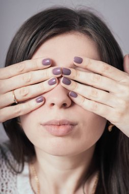 Kız elleriyle gözlerini kapatıyor.