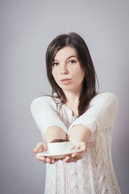 Elinde kahve çekirdeği tutan bir kız.