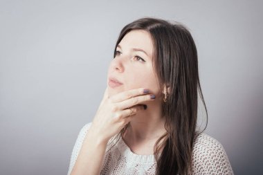 İş kadını, gri arka planda düşünceli.