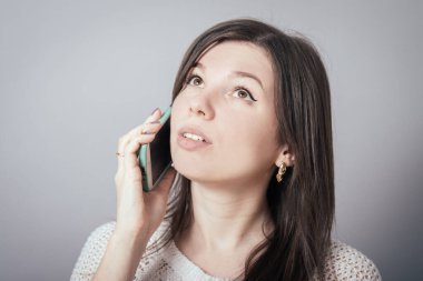 Telefonda konuşan genç kızın portresi koltukta oturuyor.