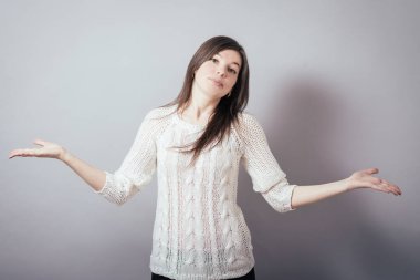 Beyaz bir arka planda genç bir kız ellerini kaldırıyor.