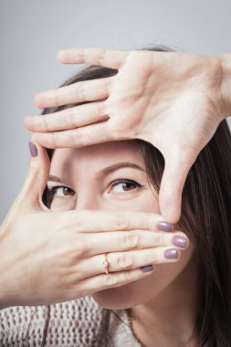 Kız gözler için bir çerçeve yapar.