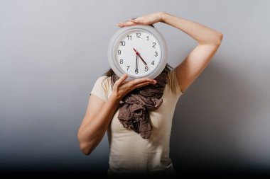 Büyük saat tutan kız.