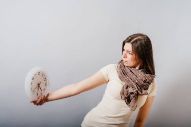 Büyük saat tutan kız.