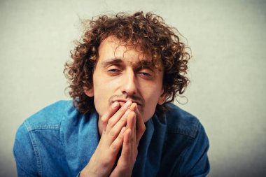 Gri arka planda dua eden bir adam