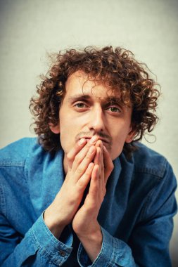 Gri arka planda dua eden bir adam