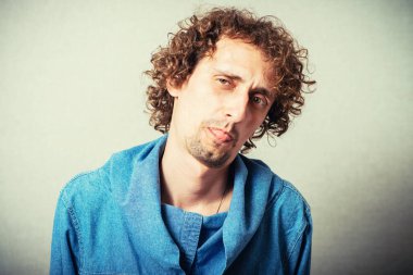 Adam gri arka planda dilini gösteriyor