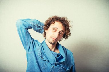 Ellerini başının arkasında tutan bir adam. 