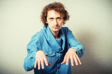 Genç adam gri arka planda ortaya çıkıyor.