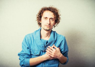 Kıvırcık adam küfreder ve elini kalbine koyar.