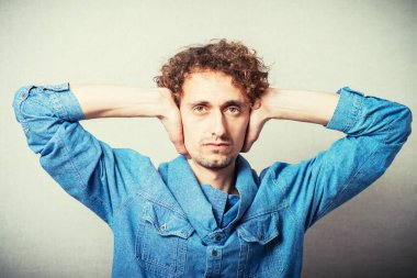 Adam kulaklarını kapatıyor.