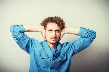 Adam kulaklarını kapatıyor.