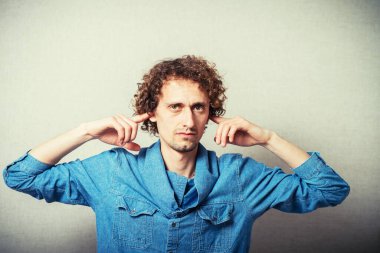 Adam kulaklarını kapatıyor.