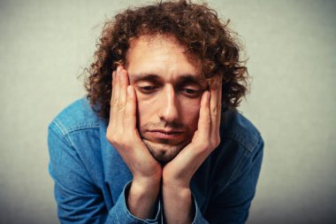 Adam çenesini ellerine koydu.