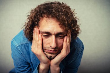 Adam çenesini ellerine koydu.