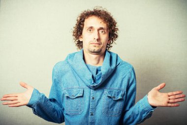 Kıvırcık saçlı adam ellerini kaldırıyor.