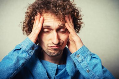Kıvırcık saçlı baş ağrısı, başını tutuyor.