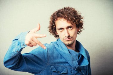 Genç adam, parmağıyla birini işaret ediyor.