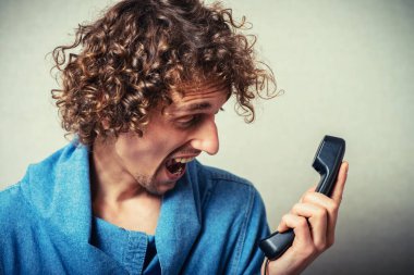 Genç kızgın adam telefonda bağırıyor.