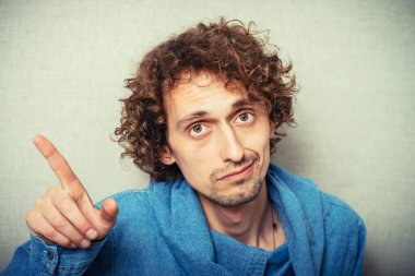 Genç adam, parmağıyla birini işaret ediyor.
