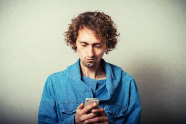 Adam beyaz bir cep telefonundan SMS çeviriyor.