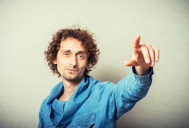 Genç adam, parmağıyla birini işaret ediyor.