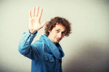 Bej arka planda poz veren kıvırcık adam