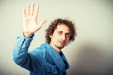 Bej arka planda poz veren kıvırcık adam