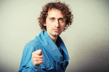 Bej arka planda poz veren kıvırcık adam