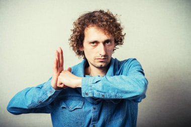 Kıvırcık kötü adam yumruğundan intikam alıyor. Gri bir arkaplanda.