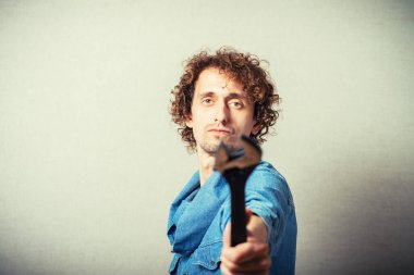 İngiliz anahtarlı kıvırcık adam. Gri bir arkaplanda.