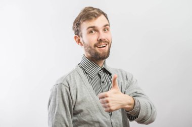 Genç adam gülümsüyor ve baş parmağını kaldırıyor..