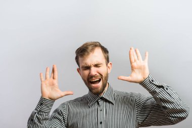 Genç adam umutsuzca bağırıyor, elleri havada.