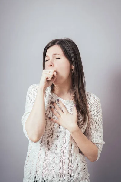 Chica Tose Sobre Fondo Gris —  Fotos de Stock