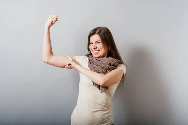 Meisje Toont Biceps Grijze Achtergrond — Stockfoto
