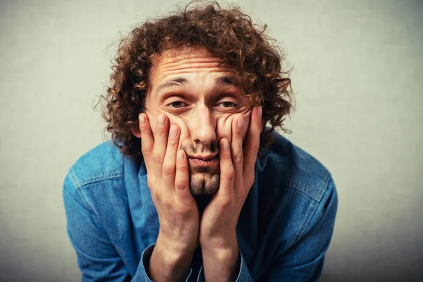 Adam çenesini ellerine koydu.