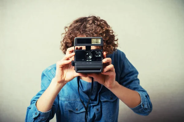 Homem Encaracolado Com Uma Câmara Fotográfica Fundo Cinza — Fotografia de Stock