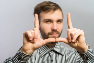 Yakışıklı bir adam çerçeveli el hareketi yapıyor - beyaz üzerine izole edilmiş.