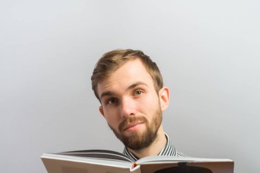 Şaşırmış hippi adam kitap okuyor.