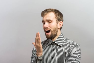 Yakışıklı genç iş adamı, elleri başının arkasında, tahta duvarda uyuyor.