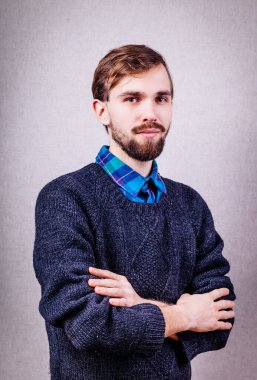Mavi kazaklı ciddi bir genç adam.