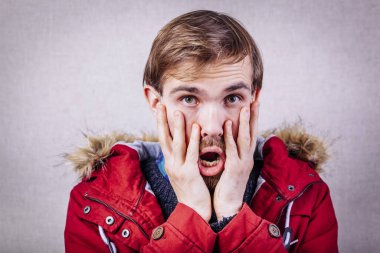 Elleri yüzü asık genç bir adam.