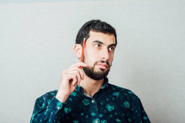 Kalemli, düşünceli, genç, havalı adamın yakın çekimi. 