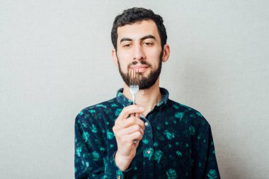 Elinde çatal olan bir adam.