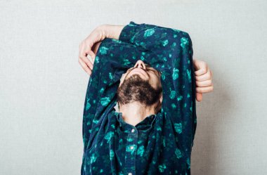 Gri arka planda genç ve yorgun bir adam. Adam uyumak istiyor. Jest yap. Fotoğraflar