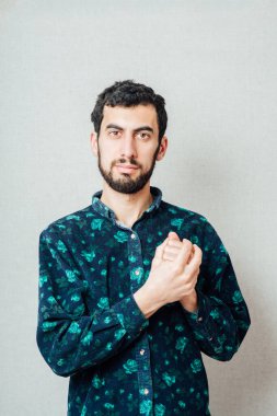 Sakallı bir adam, yumruklarını sıkıca tutuyor.