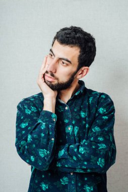 Sakallı genç bir adam hayal kırıklığına uğramış hissediyor.
