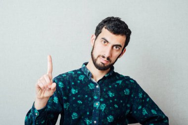 Genç bir erkeğin işaret parmağıyla fikri kavramı işaret ediyor. Retro vignette arka planında stüdyo portresi.