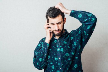 Şok olmuş iş adamı Sakal telefondaki kötü haberi okuyor.